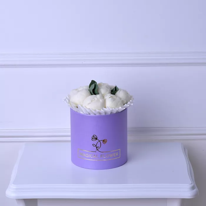 Букет из 7 белых пионов в фиолетовой шляпной коробке с эвкалиптом