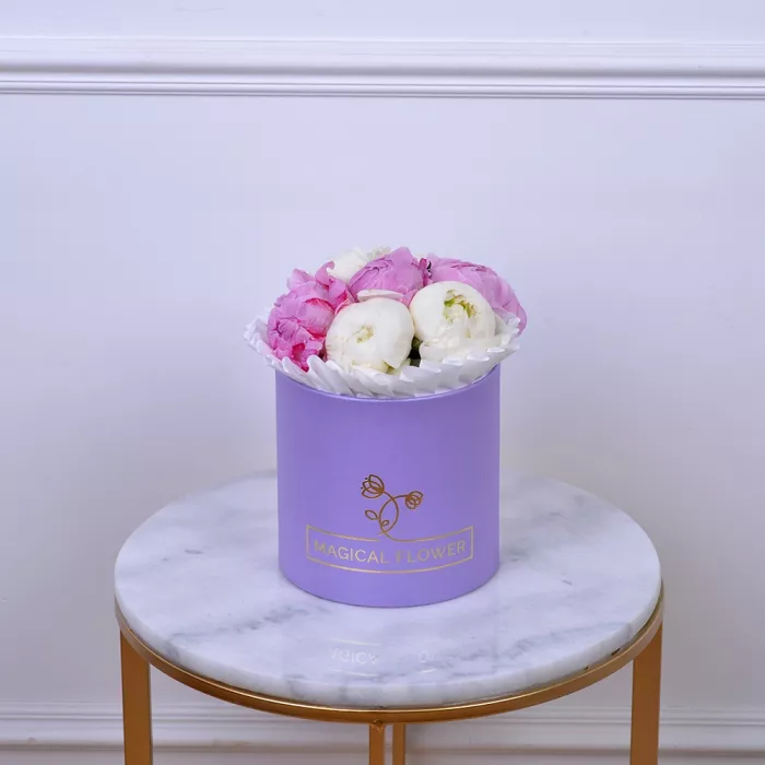 Букет из 7 разноцветных пионов в фиолетовой шляпной коробке