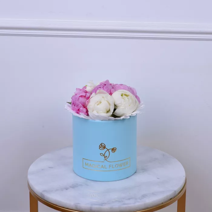 Букет из 7 разноцветных пионов в голубой шляпной коробке