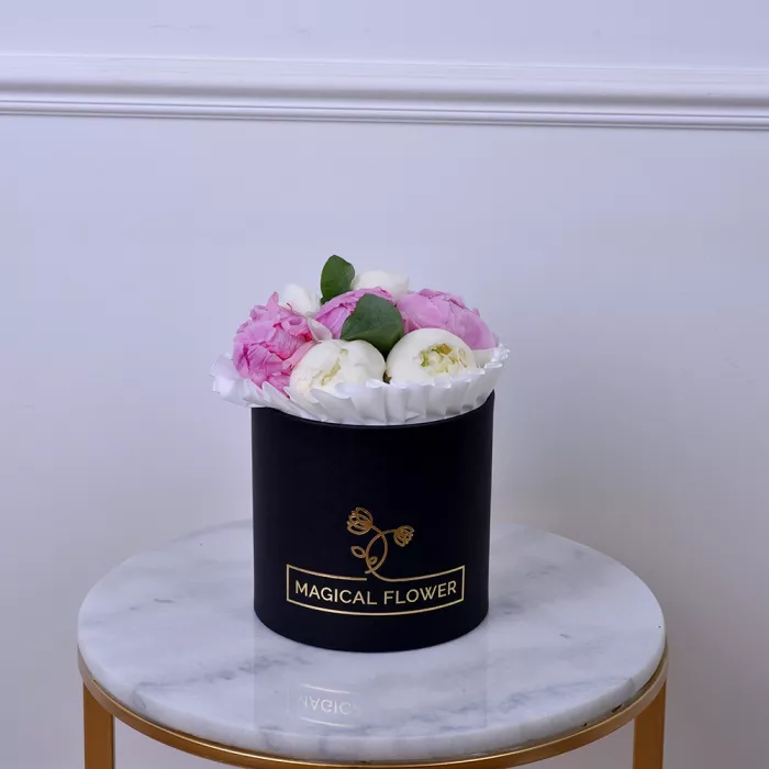 Букет из 7 разноцветных пионов с эвкалиптом в черной шляпной коробке