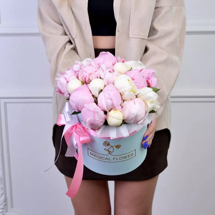 Букет из 19 разноцветных пионов в голубой шляпной коробке