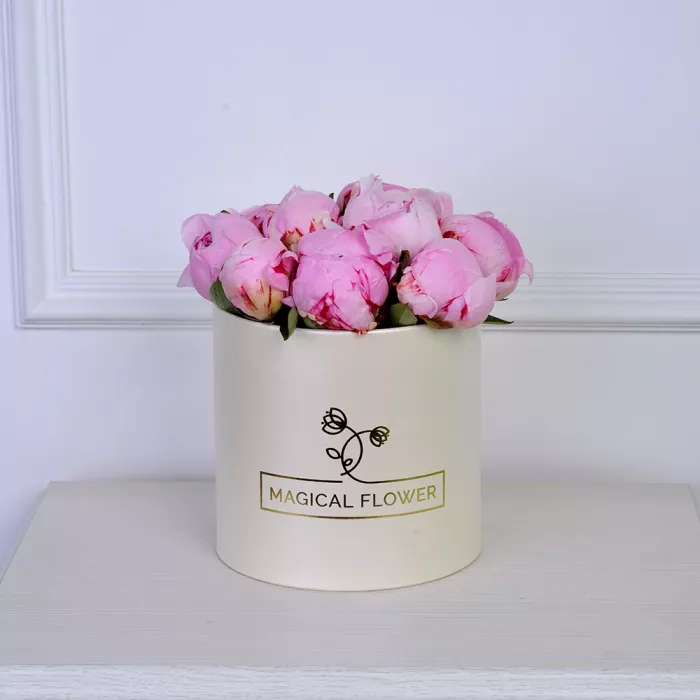 Букет из 11 розовых пионов в кремовой шляпной коробке
